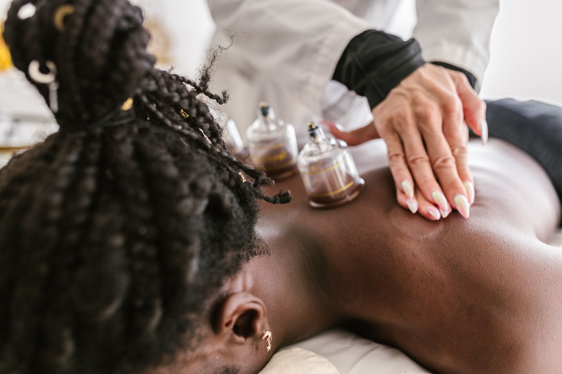 Therapist performing cupping therapy on a client's back at a spa