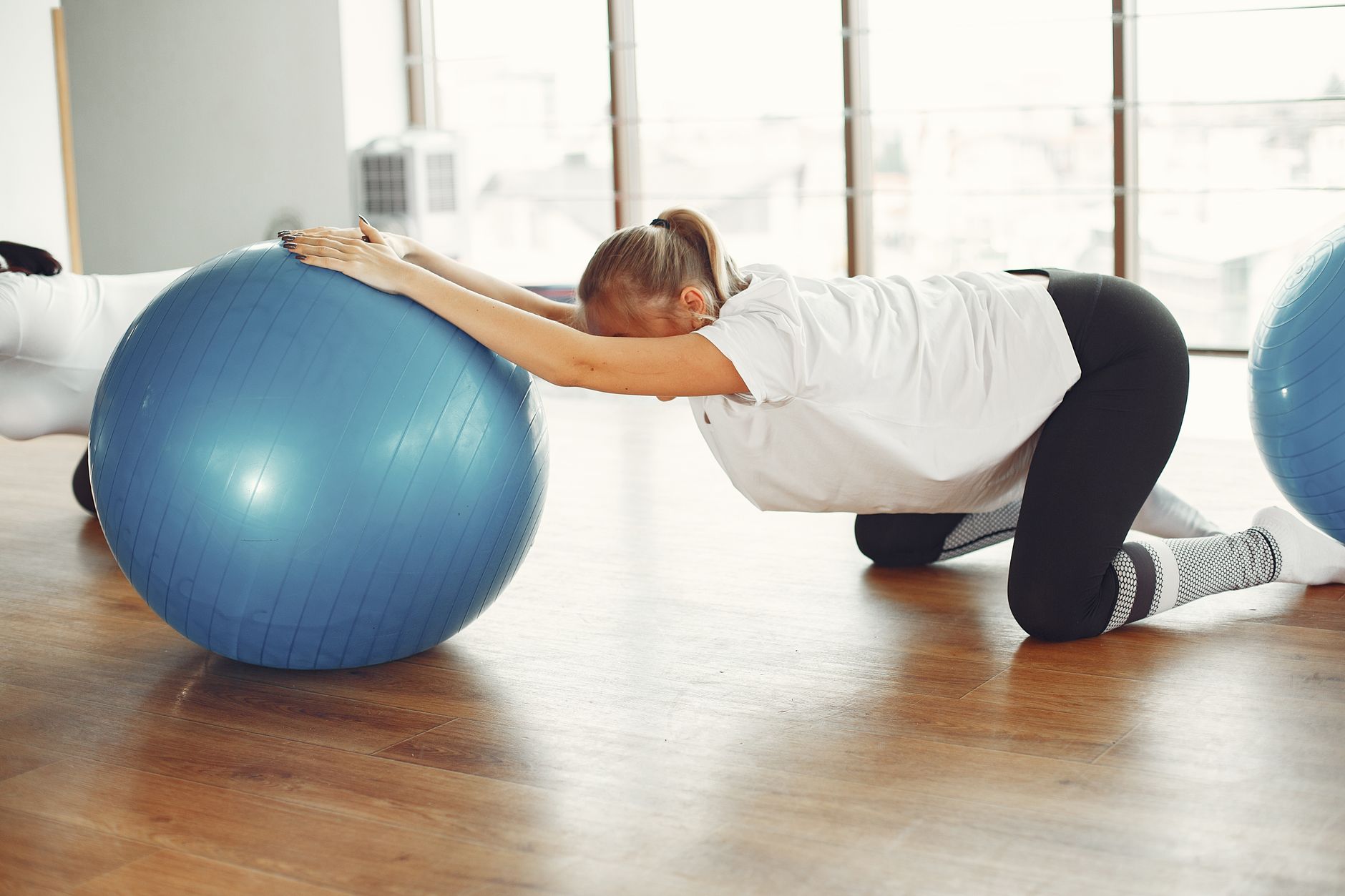 Pregnant woman doing a gentle stretching exercise with a fitness ball